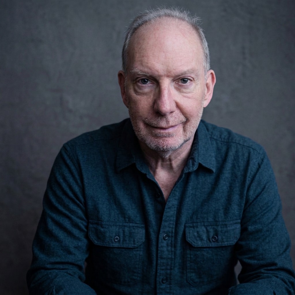 Headshot portrait of actor Chris Wells looking toward the camera, featured in character for the play production.